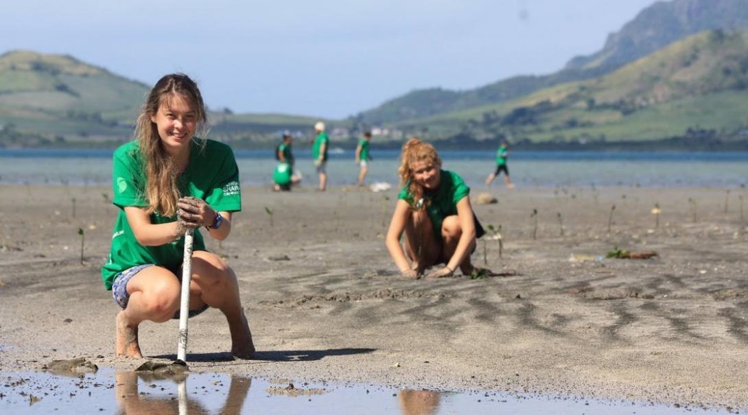 Two students on a gap year abroad plant mangroves at our Conservation Project in Fiji. Students volunteering with Projects Abroad for their gap year help plant mangroves in Fiji, South Pacific.